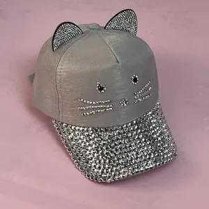 Dettaglio del berretto grigio con strass scintillanti e graziose orecchie da gatto