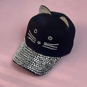 Dettaglio del cappello con orecchie di gatto e strass argentati sulla tesa lucida