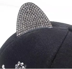 Dettaglio delle orecchie da gatto con strass su un cappellino da baseball nero scintillante