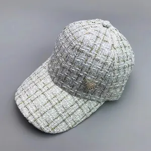 Fashionable white tweed baseball cap with a pearl heart badge and gold metallic thread