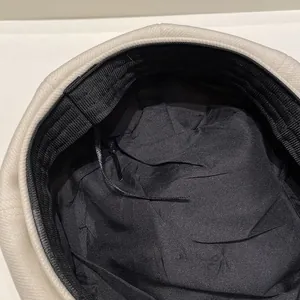 Detail of cream wool baker boy hat inner lining with adjustable drawstrings