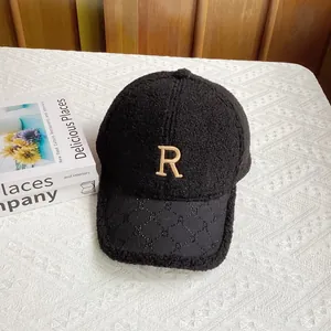 Primer plano de gorra de béisbol de lana sherpa negra con bordado R dorado y visera