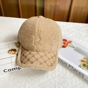Detalle de gorra sherpa caqui con letra R de diamantes y textura suave de forro polar