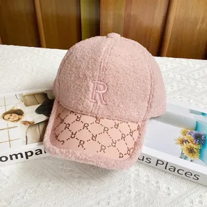 Detalle de gorra rosa de forro polar con bordado R y visera estampada para estilo invernal