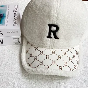 Detalle de gorra de lana de cordero con logo R de diamantes y visera de cuero