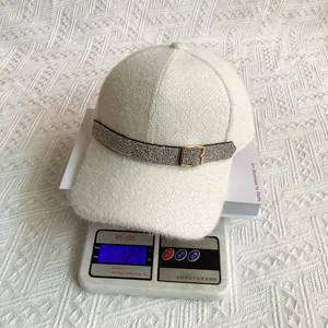 Detailed view of white plush baseball cap with sparkling rhinestone buckle weighing 127g