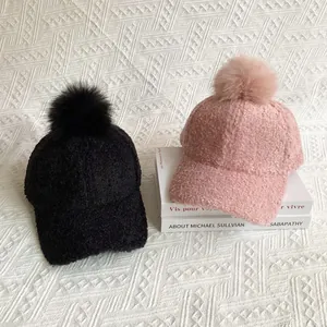Women's sherpa fleece baseball caps in black and pink with fluffy faux fox fur pom-poms
