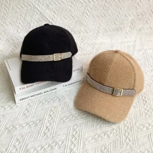 Detail of elegant baseball caps with rhinestone buckle in black and camel velvet finish