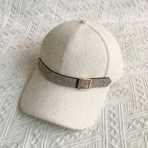 Close-up of plush knit baseball cap with rhinestone belt and golden buckle detail