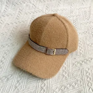 Close-up of camel plush baseball cap with sparkling rhinestone belt and gold buckle