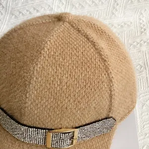 Detail of camel plush baseball cap with rhinestone strap and gold buckle accent
