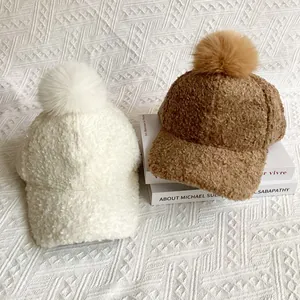 Detail shot of fluffy faux fur pom poms on soft Sherpa fleece baseball hats