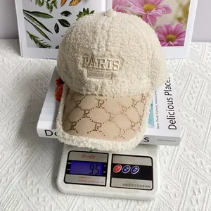 Detailed close-up of a beige lamb wool baseball cap with Paris embroidery being weighed