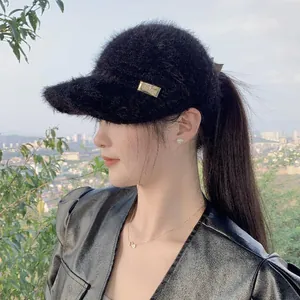 Close-up of black mohair open-top baseball cap with gold metal plate detail