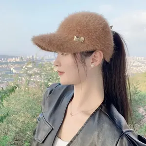 Close-up of brown faux mink fur visor with golden metallic logo plate for winter