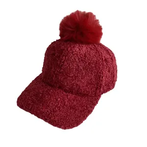 Plush burgundy baseball cap with faux fur pom-pom and thick lamb wool texture