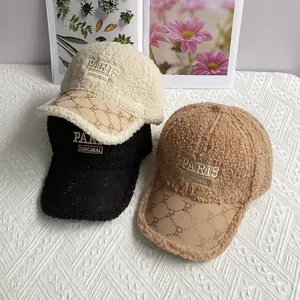 Detail of plush sherpa baseball caps with Paris embroidery in cream, black and khaki