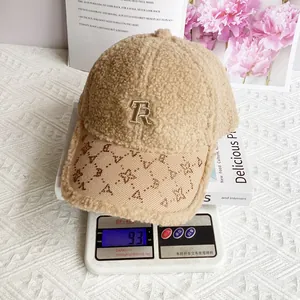 Dettaglio del cappello in lana d'agnello con ricamo TR su una bilancia da 93 grammi