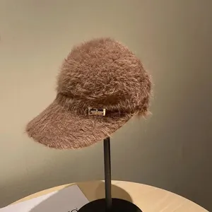 Detailed view of brown faux mohair fabric and gold logo plate on winter topless cap