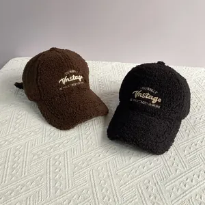 Gros plan de casquettes de baseball en laine d'agneau avec broderie en noir et marron foncé