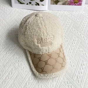 Detail of Paris embroidery on cream teddy fleece baseball cap with R-patterned brim