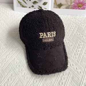 Detail of black faux shearling baseball cap with golden PARIS embroidery and rhinestone brim
