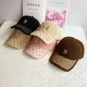 Pile di cappellini in lana d'agnello in quattro colori con logo R ricamato