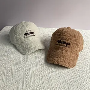 Détail des casquettes de baseball en sherpa beige et marron avec broderie vintage