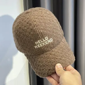 Detail van de donkerbruine imitatie kasjmier baseballpet met HELLO WEEKEND borduursel