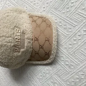 Close-up of beige faux shearling baseball cap with PARIS embroidery and R logo detail