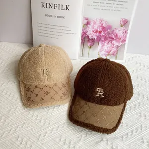 Primo piano di cappellini da baseball in pile beige e marrone con ricamo TR e visiera