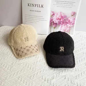 Dettaglio di cappellini da baseball in lana di agnello con ricamo R e piccoli strass