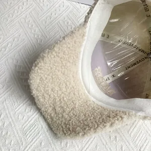 Detail of beige fleece baseball cap showing textured fabric and printed inner sweatband