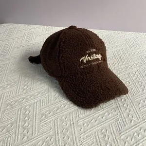 Détail de la casquette de baseball en laine d'agneau marron avec broderie dorée