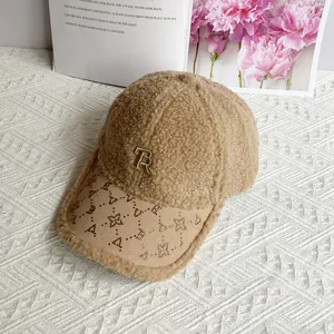 Dettaglio del cappello in lana d'agnello cammello con logo R di strass e visiera borchiata