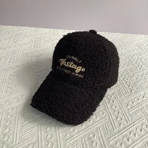 Détail d'une casquette de baseball en polaire noire avec broderie vintage sur tissu