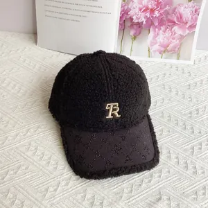 Dettaglio cappello in lana di agnello nera con logo TR dorato e visiera con strass