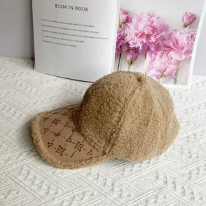 Dettaglio cappello in lana d'agnello color cammello con visiera in velluto e monogramma