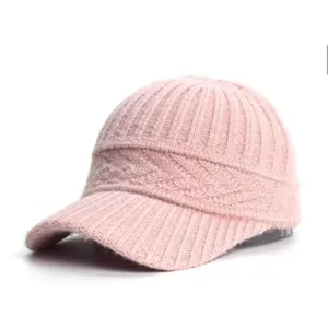 Detailed close-up of pink knitted baseball cap with ribbed texture and warm plush material
