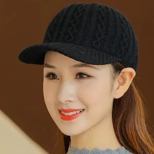 Detail of black knit baseball cap showing chunky cable pattern and stiff brim