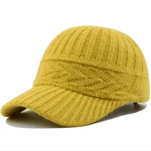 Detailed close-up of yellow knitted baseball cap showing intricate textured wave patterns