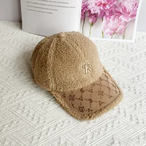 Dettaglio del cappellino beige in lana di agnello con ricamo di lettere in strass