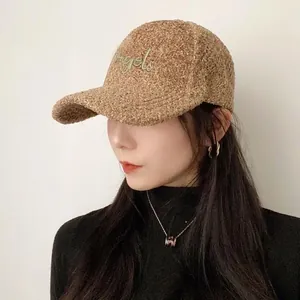 Close-up of khaki teddy fleece texture and gold Angels embroidery on the baseball cap