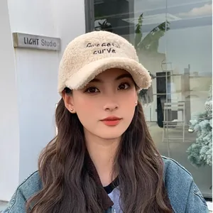 Detail of Graceful Curve embroidery on warm beige faux shearling baseball cap