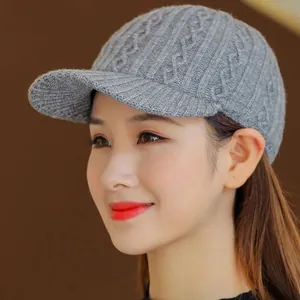 Close-up of a women's gray knitted baseball cap with fine diamond pattern texture