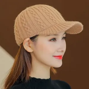 Close-up of women's camel knit baseball cap featuring classic cable stitch pattern
