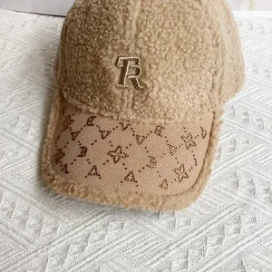 Dettaglio ravvicinato di cappello in pile con ricamo TR e decorazioni in strass brillanti