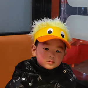 Détail de la broderie d'yeux de dessin animé et perruque sur casquette enfant