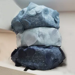 Three denim beret hats with 3D heart embroidery in light, grey, and dark blue shades