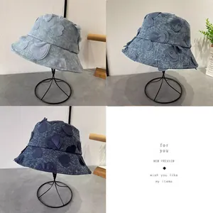 Detail showing three denim bucket hats with 3D heart embroidery in various blue washes